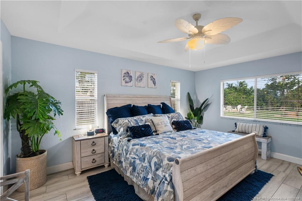 2457 Southeast Issac Road Port St. Lucie, FL 34952 - Photo 2 of 51 a bedroom with a large bed and a window