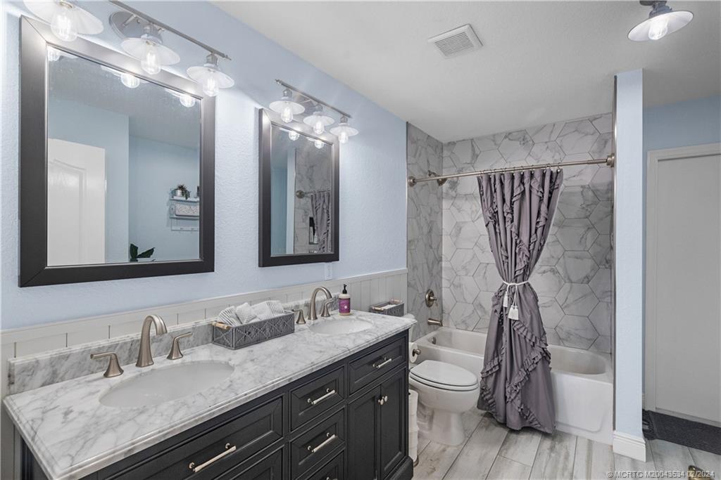 2457 Southeast Issac Road Port St. Lucie, FL 34952 - Photo 24 of 51 a bathroom with a granite countertop sink toilet and shower