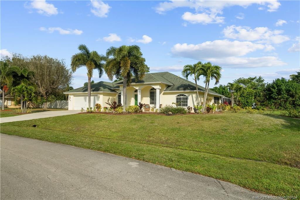 2457 Southeast Issac Road Port St. Lucie, FL 34952 - Photo 6 of 51 a front view of a house with a garden