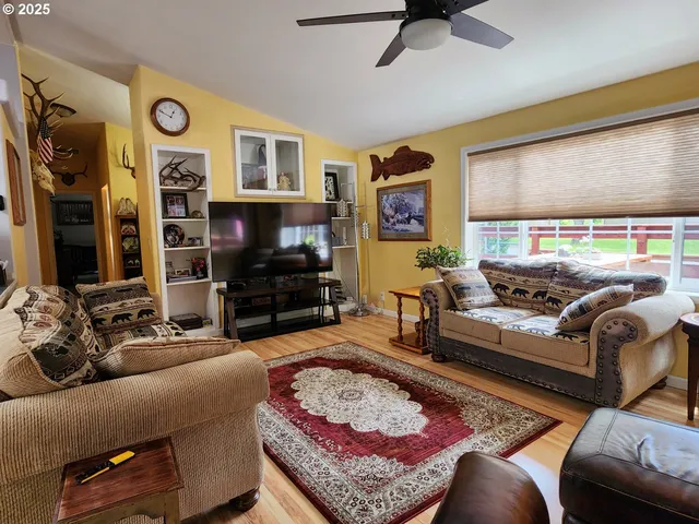 a living room with furniture ceiling fan and a window