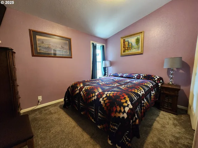 a bed sitting in a bedroom next to a lamp