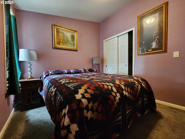 a bed sitting in a bedroom next to a lamp