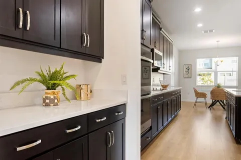 a kitchen with stainless steel appliances granite countertop a sink a stove and a wooden floors