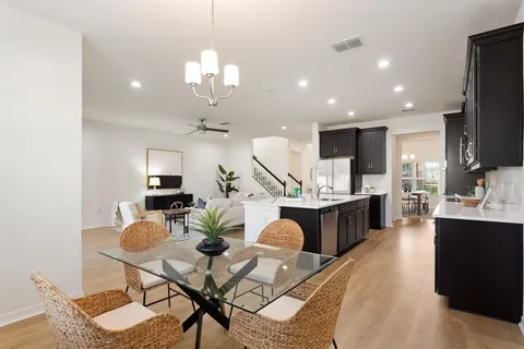 a kitchen with stainless steel appliances kitchen island granite countertop a stove a sink a refrigerator and chairs