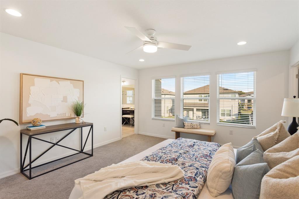 11127 Sundrift Drive Tampa, FL 33647 - Photo 26 of 44 a spacious bedroom with a bed a couch and large window