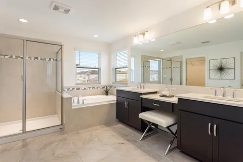 a bathroom with a sink a toilet and a large mirror