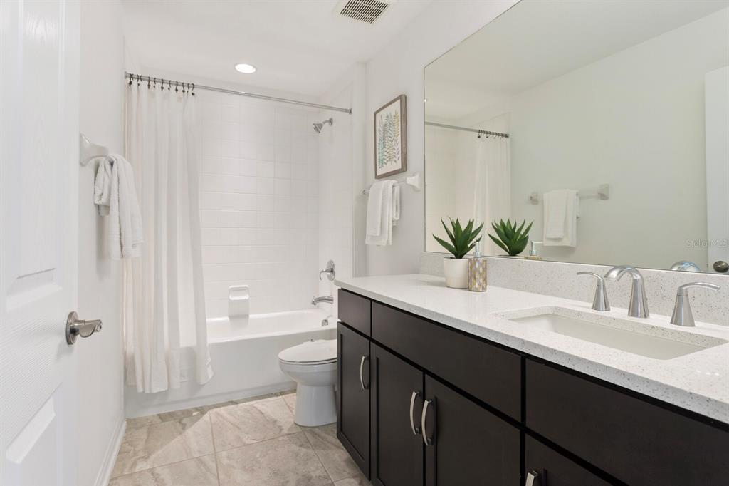11127 Sundrift Drive Tampa, FL 33647 - Photo 31 of 44 a bathroom with a double vanity sink toilet mirror and shower