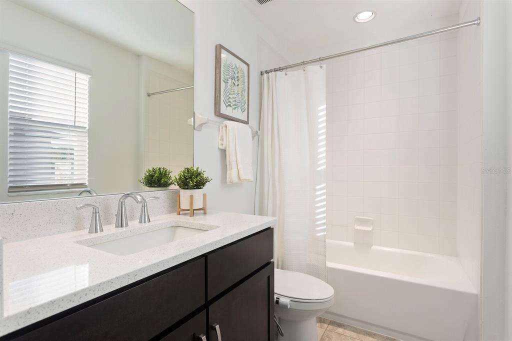 11127 Sundrift Drive Tampa, FL 33647 - Photo 34 of 44 a bathroom with a sink a toilet and a large mirror