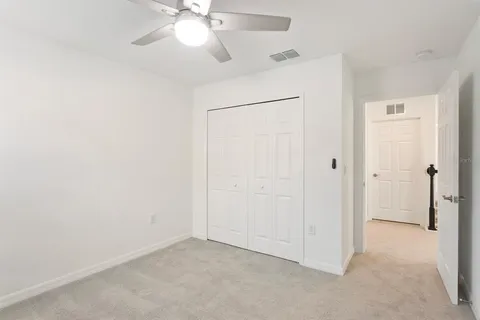 a view of swimming pool with lawn chairs and large trees