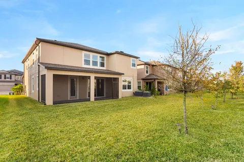 a view of house with backyard and outdoor seating