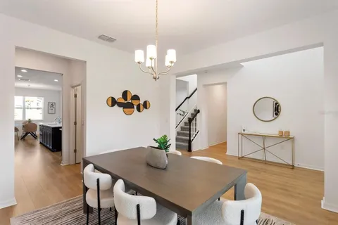 a view of a dining room with furniture a chandelier and wooden floor