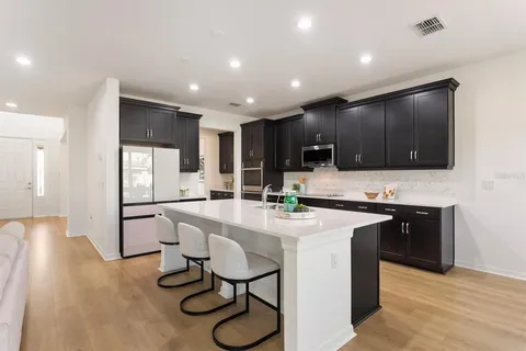 a kitchen with stainless steel appliances kitchen island granite countertop a refrigerator and a stove top oven