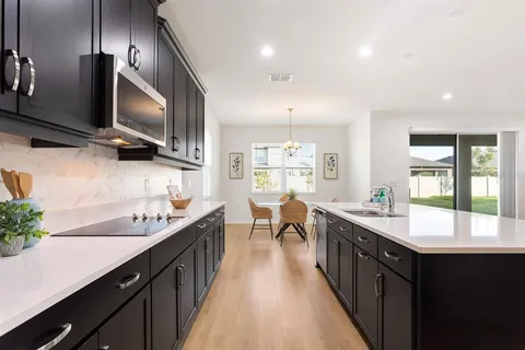 a kitchen with kitchen island granite countertop a sink appliances cabinets and a counter top space