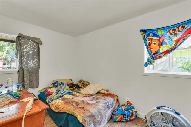 a bedroom with a bed that has a blanket on it and next to a window