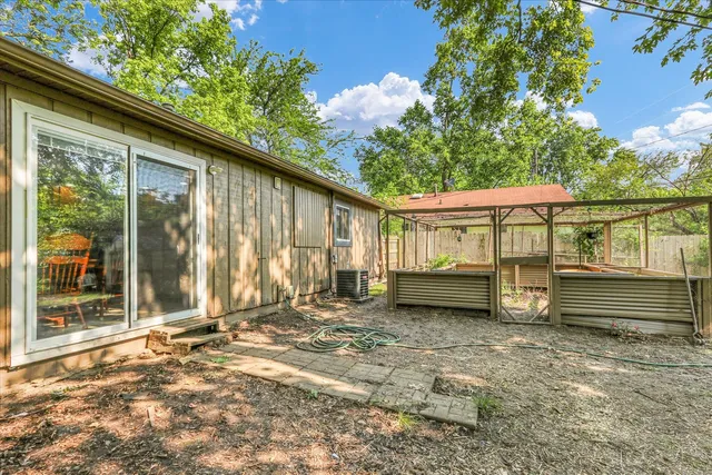 a backyard of a house with barbeque oven table and chairs