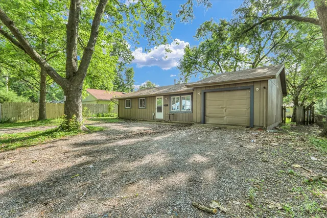 a view of a house with a yard and large tree