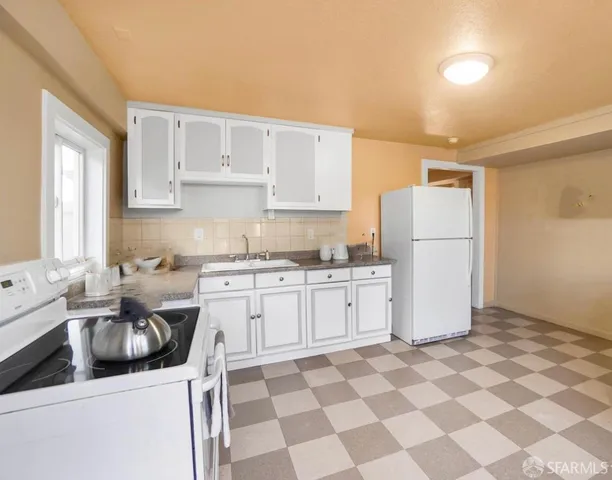 a kitchen with a refrigerator sink stove and cabinets