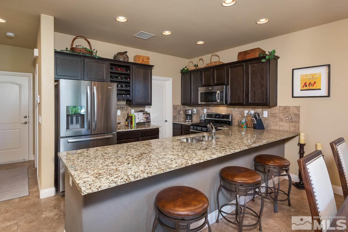 10701 Cordero Drive Reno, NV 89521 - Photo 6 of 25 a kitchen with stainless steel appliances granite countertop a sink and a refrigerator