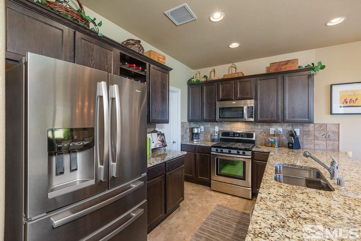 10701 Cordero Drive Reno, NV 89521 - Photo 7 of 25 a kitchen with stainless steel appliances granite countertop a refrigerator a stove and a sink