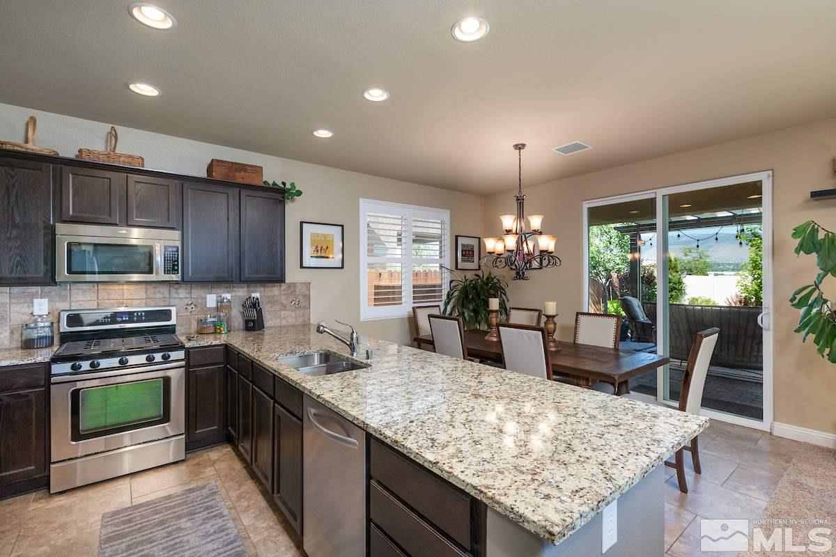 10701 Cordero Drive Reno, NV 89521 - Photo 8 of 25 a kitchen with stainless steel appliances granite countertop a stove top oven a sink dishwasher a dining table and chairs
