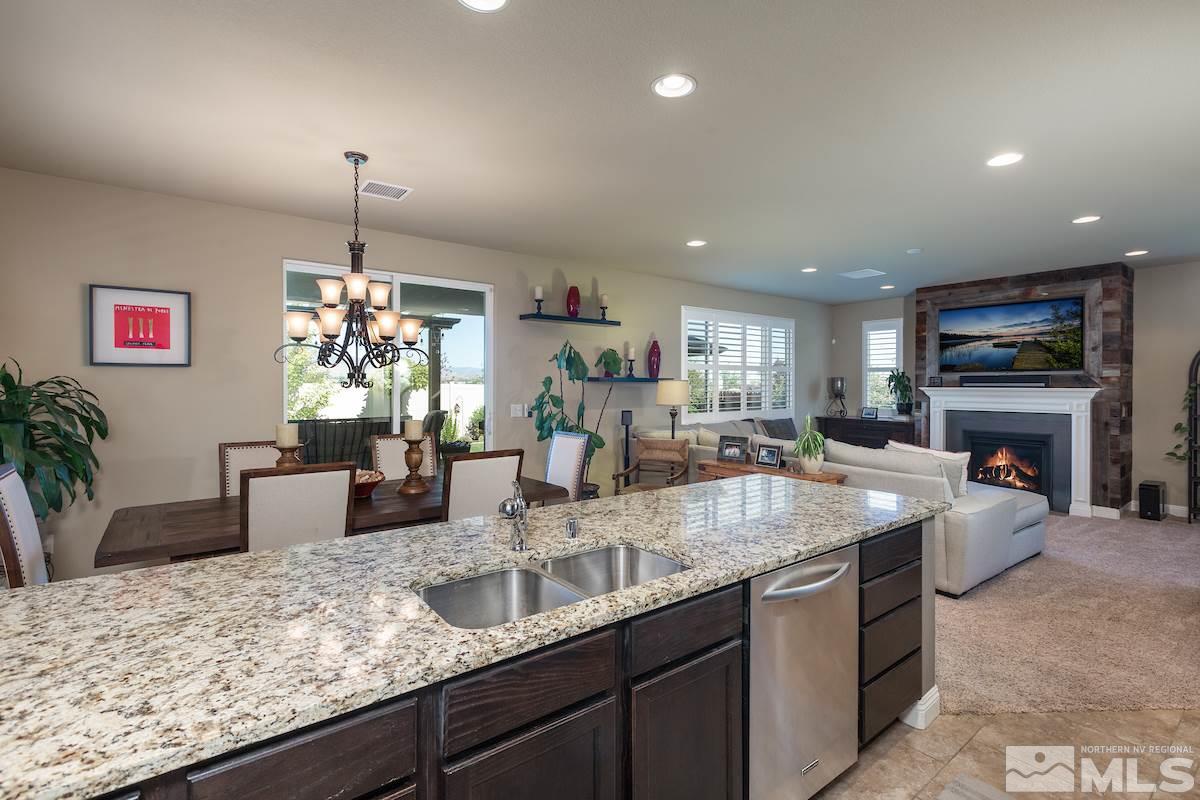 10701 Cordero Drive Reno, NV 89521 - Photo 9 of 25 a kitchen with kitchen island granite countertop a sink a counter top space and living room view