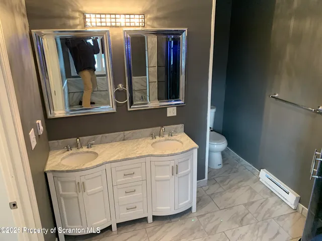 a bathroom with a granite countertop sink and mirror