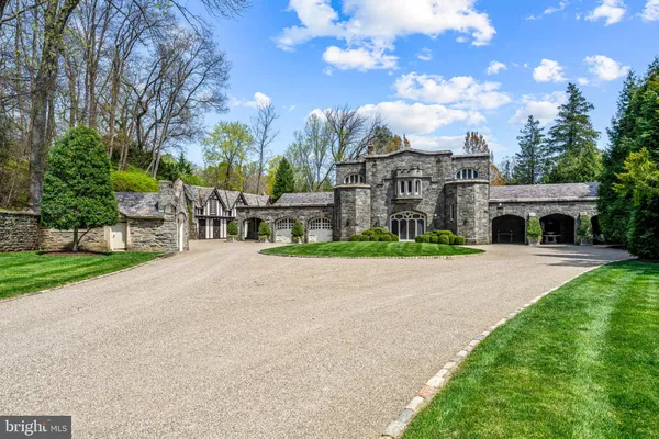 a view of a house with a yard and large trees
