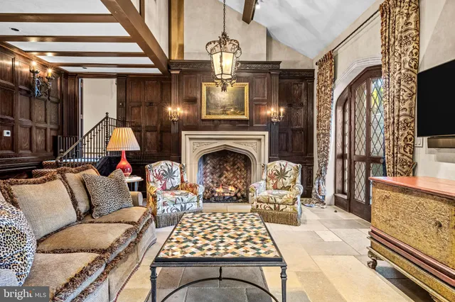 a living room with furniture a fireplace and a floor to ceiling window