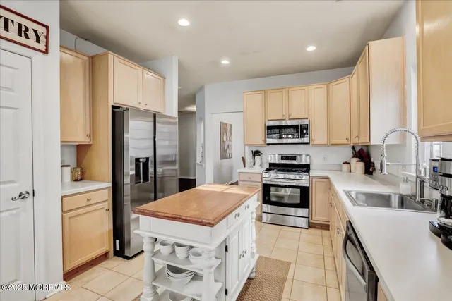 a kitchen with stainless steel appliances a refrigerator sink and stove