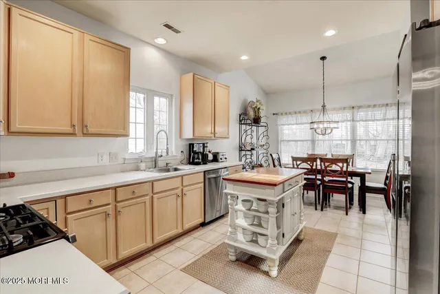 a kitchen with kitchen island granite countertop a sink table and chairs