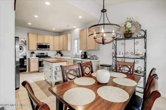 a view of a dining room with furniture a chandelier and wooden floor
