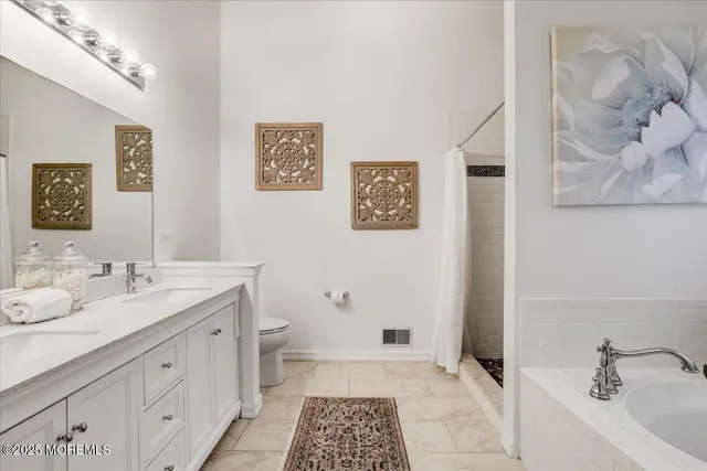 a bathroom with a double vanity sink a mirror and a toilet