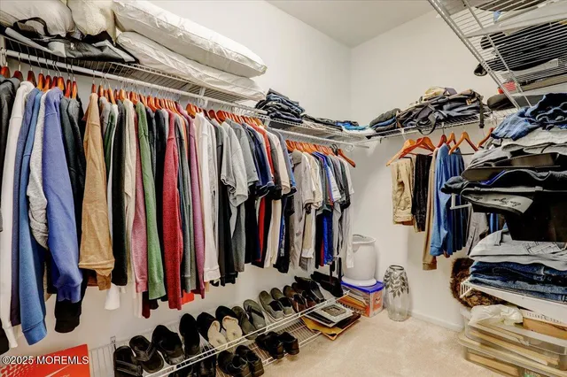 a view of walk in closet with clothes