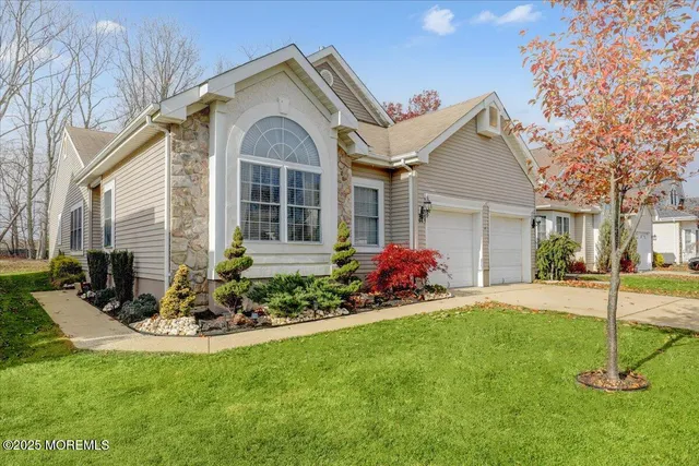 a front view of a house with a big yard and potted plants