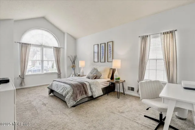 a spacious bedroom with a bed and windows