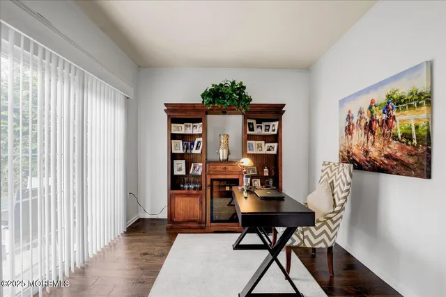 a view of a workspace with furniture and a window