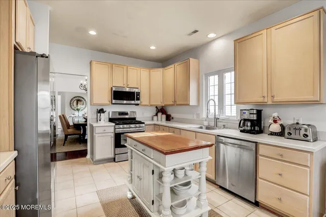 a kitchen with granite countertop a sink stainless steel appliances and cabinets