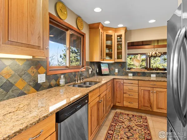 a kitchen with stainless steel appliances granite countertop a sink and wooden cabinets