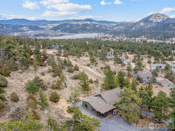 an aerial view of house with yard and mountain view in back