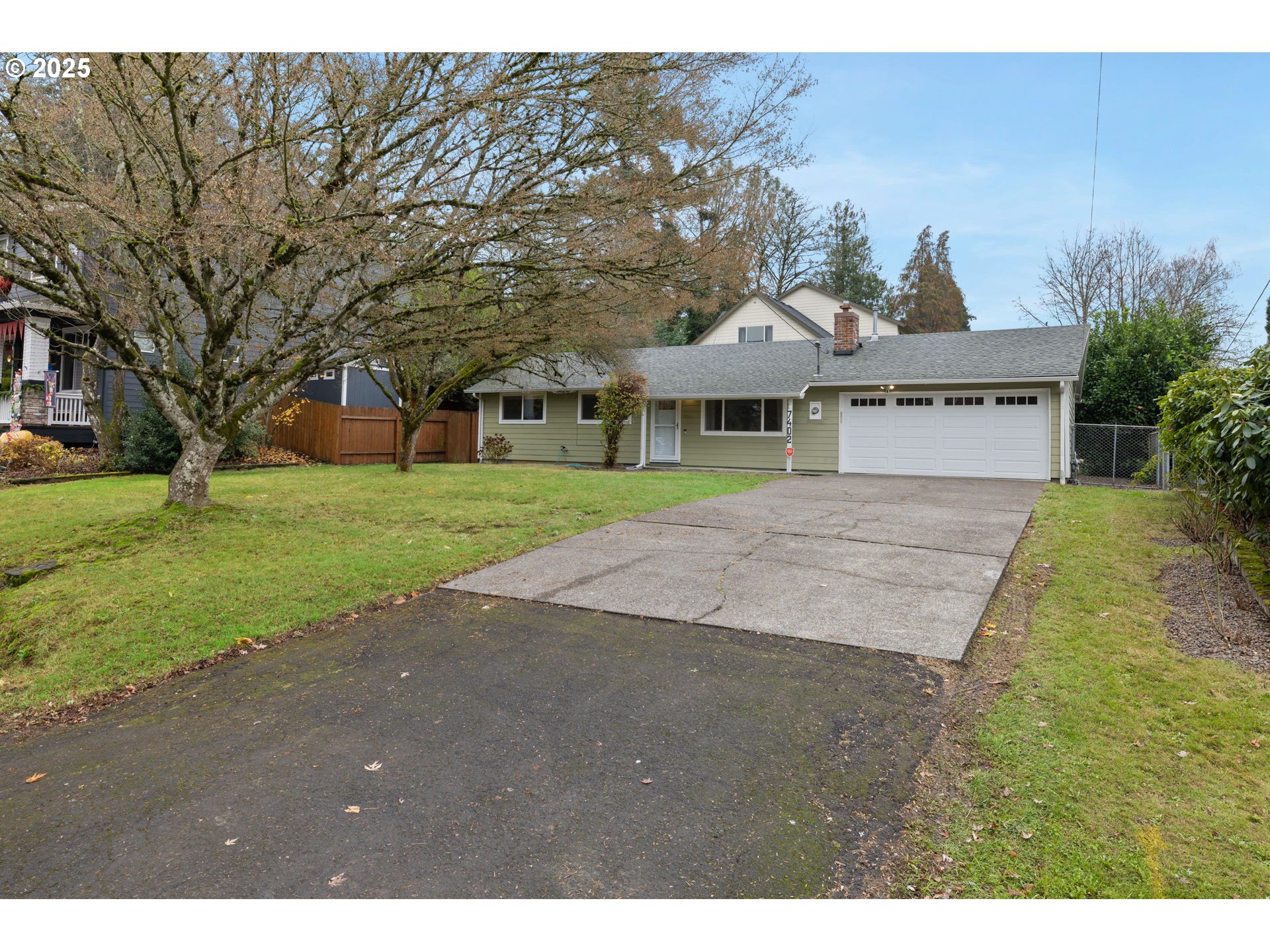 7402 Southwest Locust Street Portland, OR 97223 - Photo 2 of 25 a front view of a house with a yard and garage