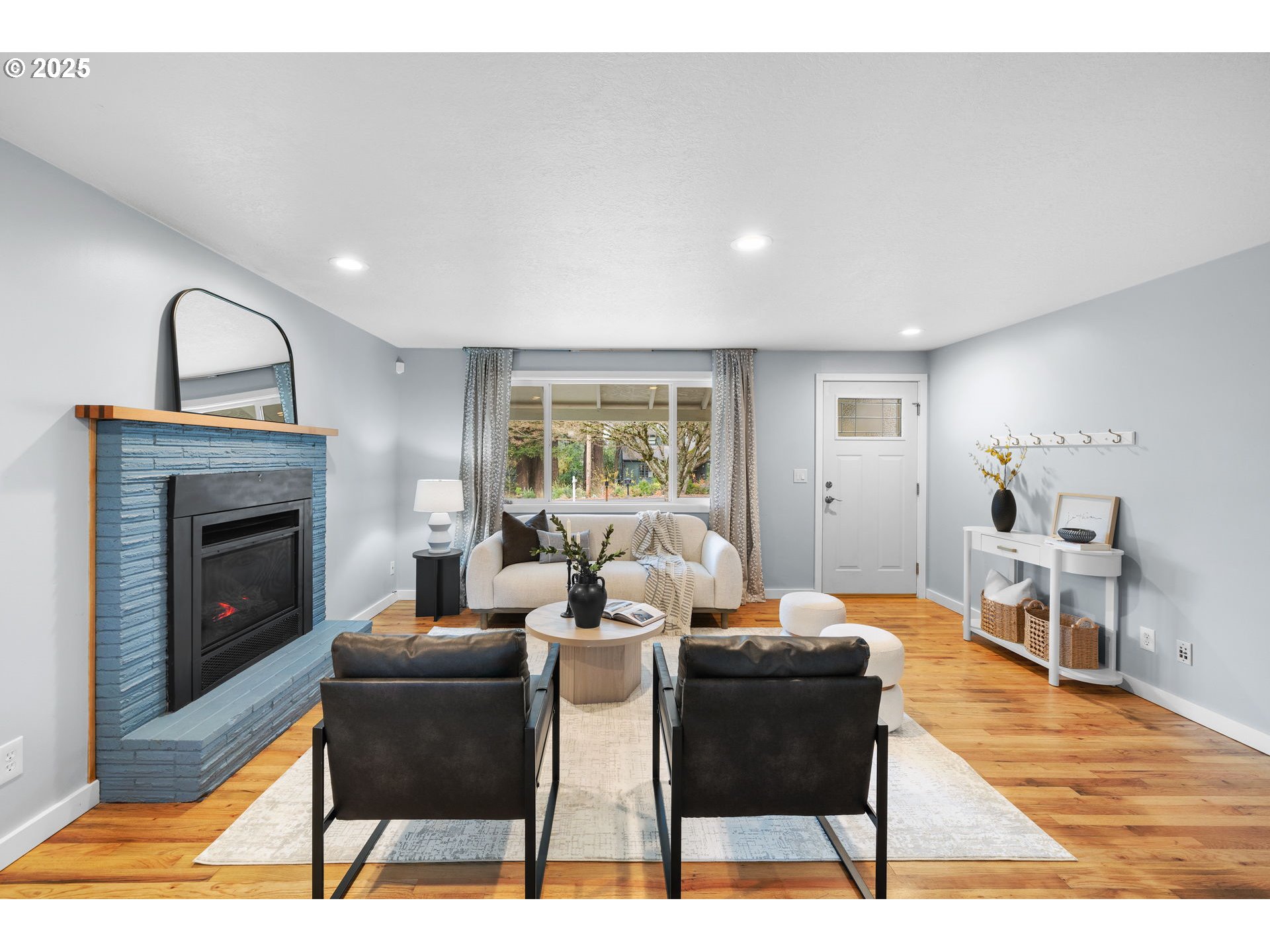 7402 Southwest Locust Street Portland, OR 97223 - Photo 6 of 25 a living room with furniture a fireplace and a table