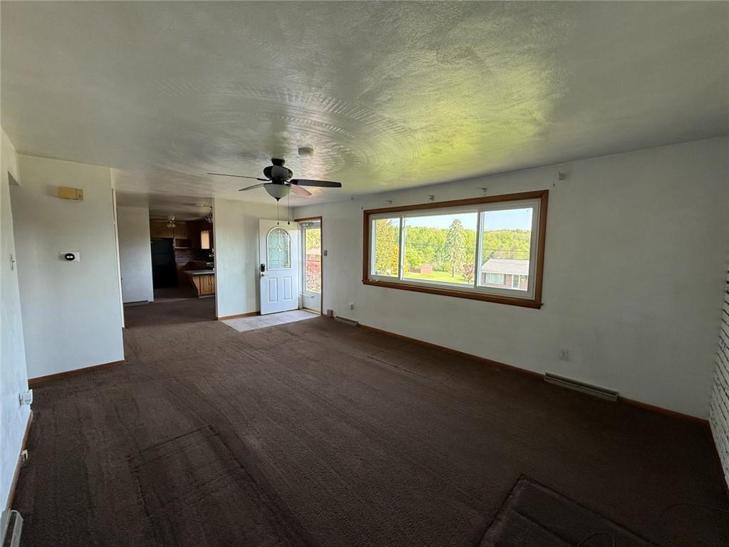 105 Ridgeview Drive Salix, PA 15952 - Photo 14 of 25 an empty room with a fireplace and windows