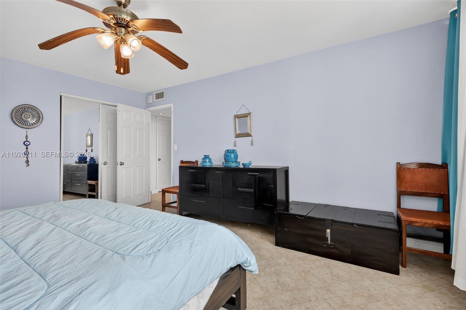 7135 Collins Avenue, Unit 1015 Miami Beach, FL 33141 - Photo 21 of 41 a bedroom with a bed and a chandelier