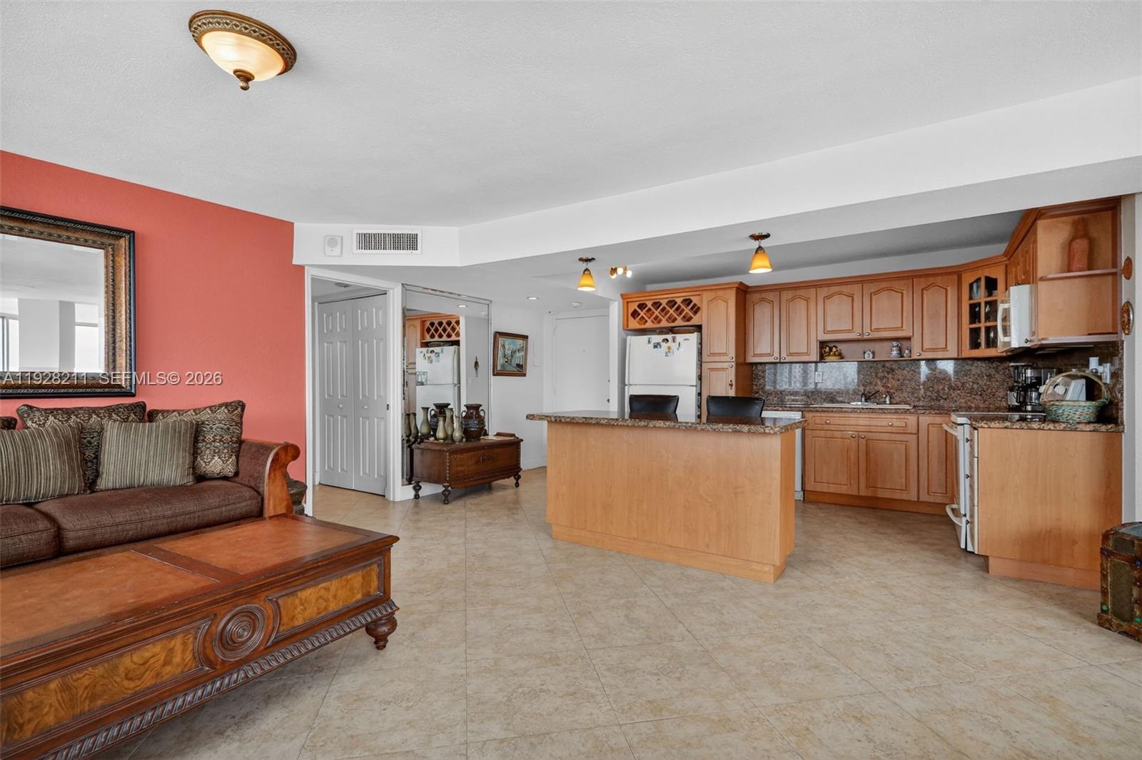 7135 Collins Avenue, Unit 1015 Miami Beach, FL 33141 - Photo 5 of 41 a living room with furniture a kitchen island a sink and a stove