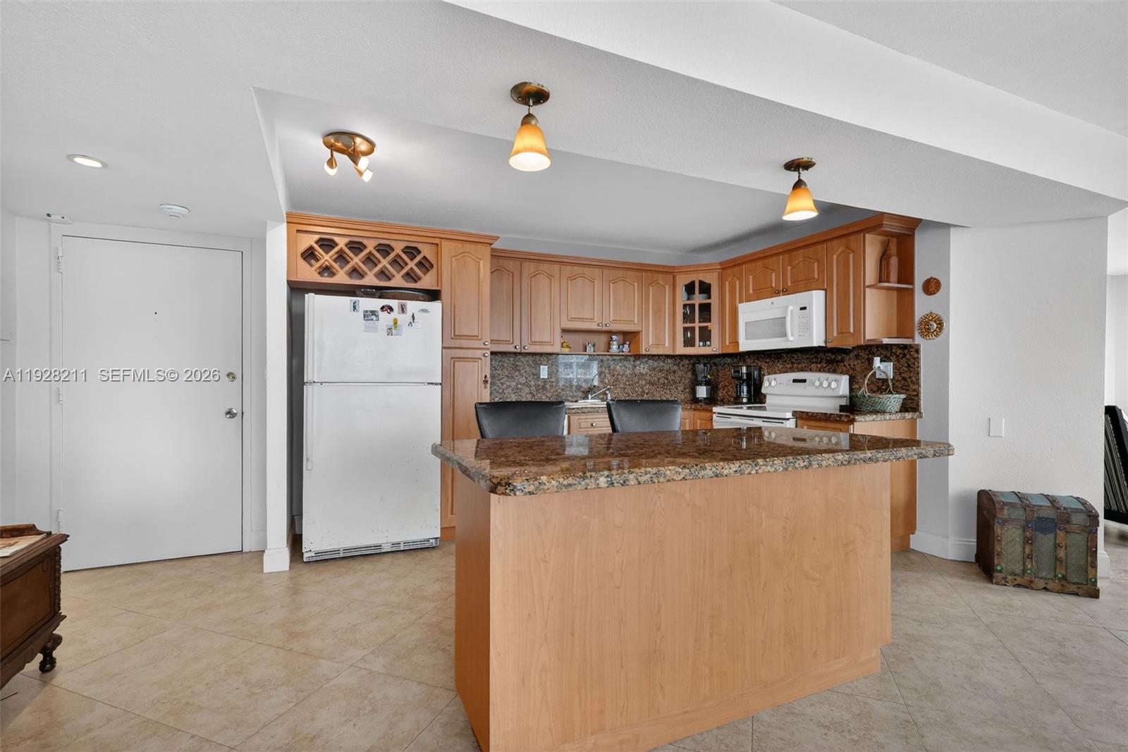 7135 Collins Avenue, Unit 1015 Miami Beach, FL 33141 - Photo 6 of 41 a kitchen with stainless steel appliances granite countertop a refrigerator a stove top oven a sink and dishwasher