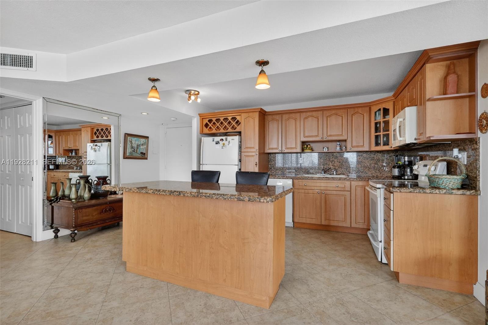 7135 Collins Avenue, Unit 1015 Miami Beach, FL 33141 - Photo 7 of 41 a kitchen with cabinets a sink and appliances