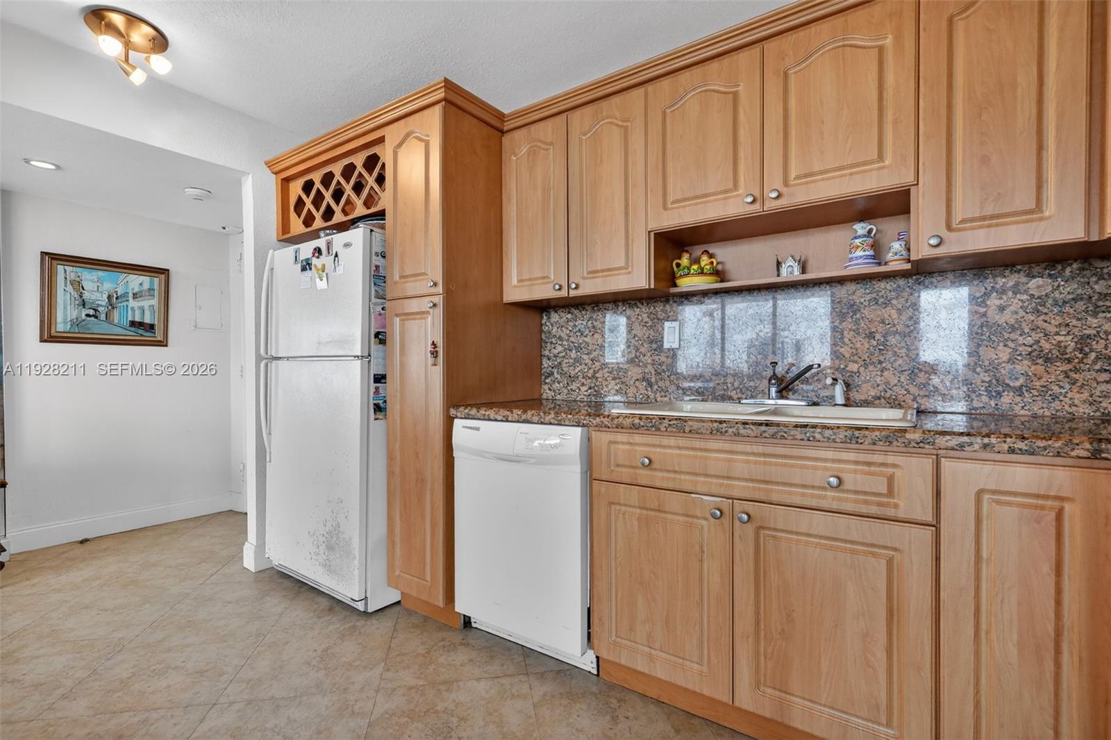 7135 Collins Avenue, Unit 1015 Miami Beach, FL 33141 - Photo 9 of 41 a kitchen with stainless steel appliances granite countertop a refrigerator sink and cabinets
