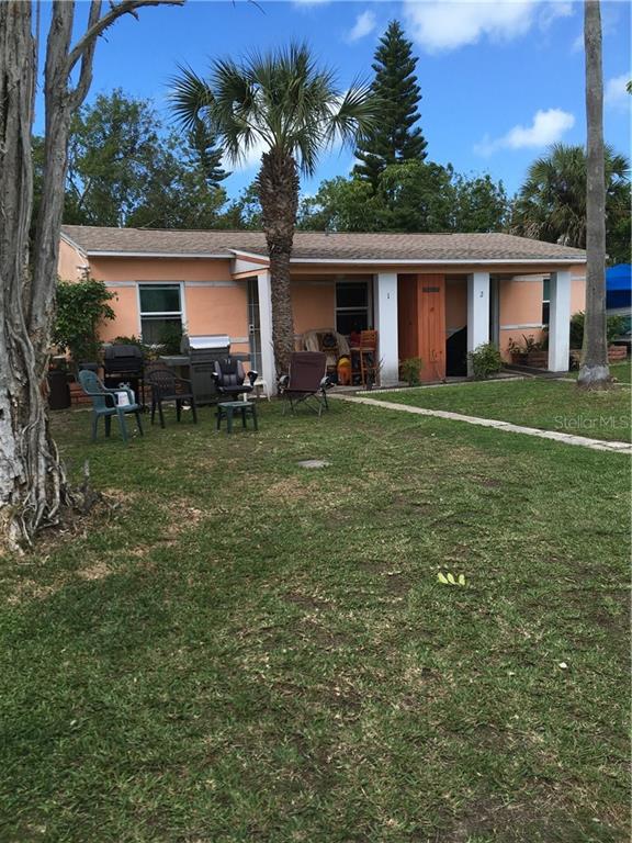 14016 East Parsley Drive Madeira Beach, FL 33708 - Photo 1 of 1 a front view of house with yard outdoor seating and green space
