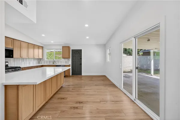 a kitchen with stainless steel appliances granite countertop a refrigerator and a sink