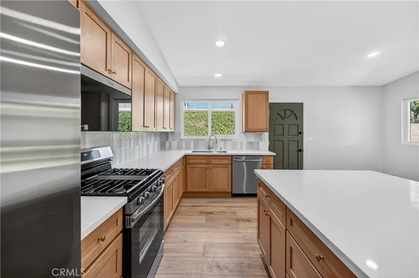 a kitchen with stainless steel appliances a sink stove and cabinets